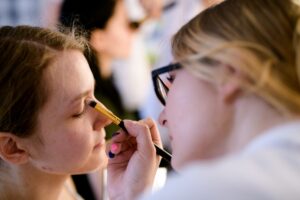 Słuchaczki ćwiczą makijaż na modelkach podczas zajęć
