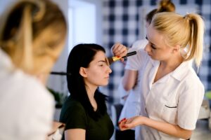 Słuchaczki ćwiczą makijaż na modelkach podczas zajęć