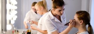 Słuchaczki ćwiczą makijaż na modelkach podczas zajęć
