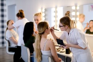 Słuchaczki ćwiczą makijaż na modelkach podczas zajęć