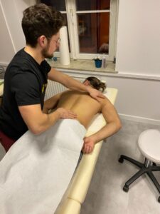 Ćwiczenia masażu nogi na modelce podczas zajęć