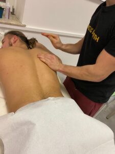 Słuchacz wykonuje masaż pleców na modelce