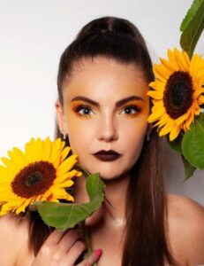 Artystyczny makijaż modelki z motywem słoneczników